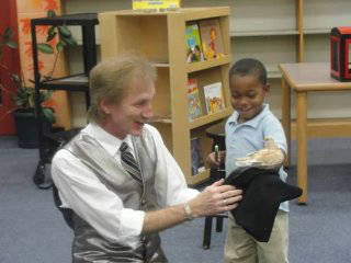 a child volunteer makes the bird appear with Rodney the Magician