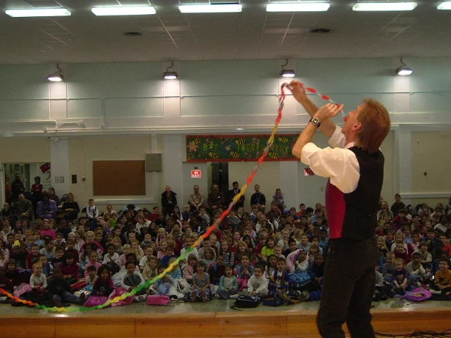 Nashville Magician Rodney Kelley performing a paper trick in front of a school