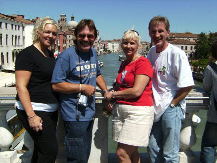 Crystal Stupar, Rick Moore, Donna Moore, Rodney Kelley posing in Venice Italy with the canal in background.