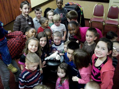 children petting a bird after the magic show