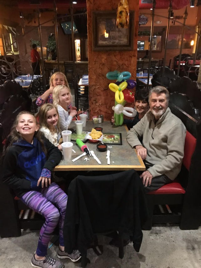 family sitting with balloon animals in their booth at Mexicali Grill