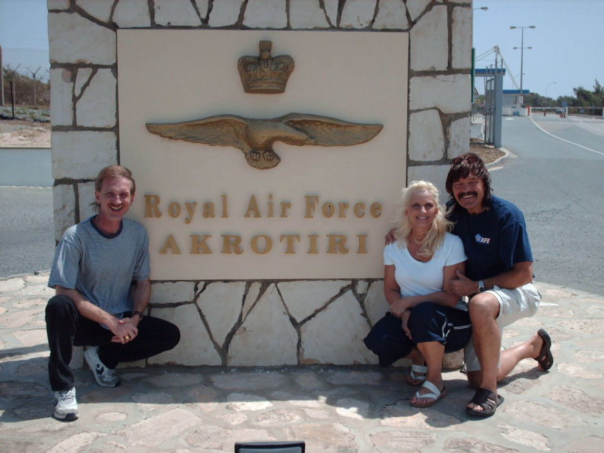 Donna Moore, Rick Moore, Rodney Kelley standing next to the sign for Akrotiri Royal Air Force Base in Crete, Greece