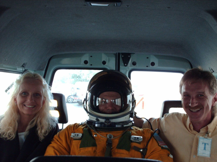 Rodney Kelley, Donna Moore, Rick Moore standing in car driving pilot to U-2 plane in Crete Greece