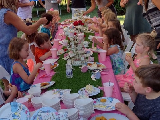 children sitting around a table having cake at a birthday party