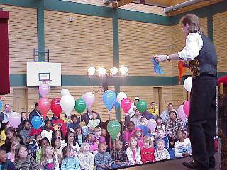Nashville Magician Rodney Kelley performing silk trick in front of large group of children