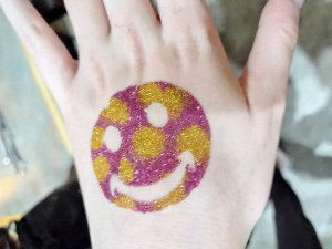 smiley face gold and red glitter tattoo